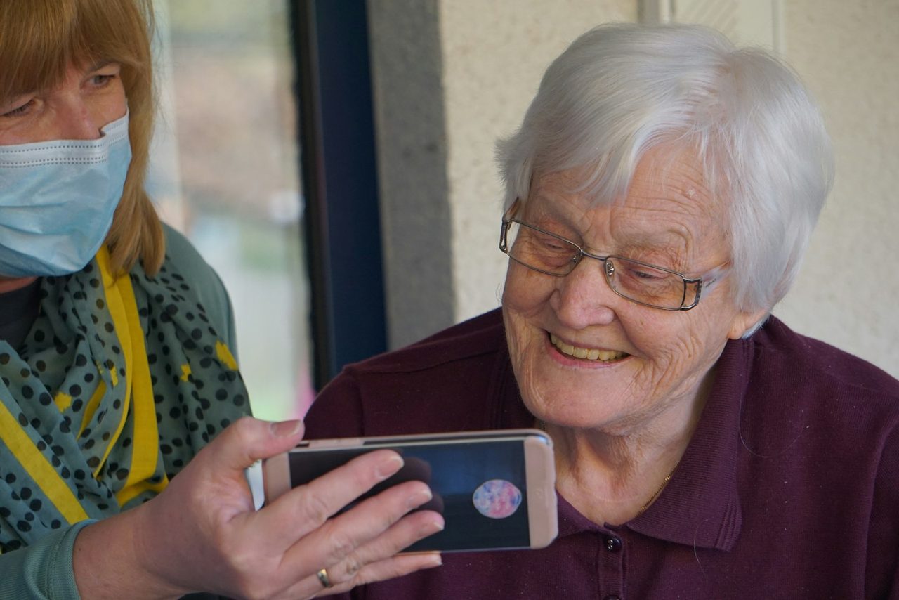 An allied health practitioner supporting a patient on a device